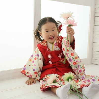 白地の小花のかわいい着物に赤の被布の衣装で七五三撮影